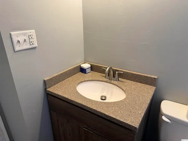 a bathroom with a granite countertop sink and a mirror