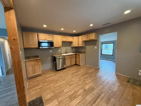 a kitchen with stainless steel appliances granite countertop a stove a sink and a refrigerator