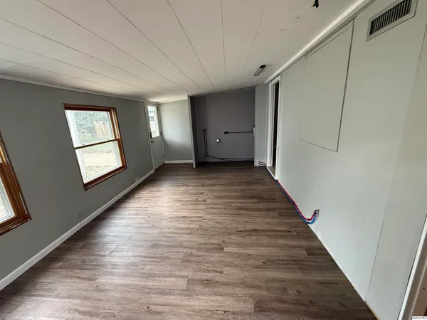 a view of a hallway with wooden floor and windows
