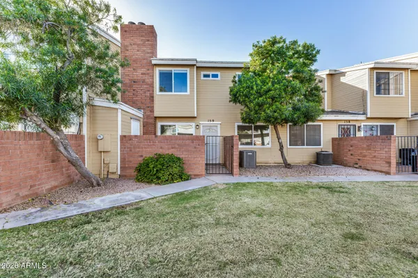 a view of a house with a yard and a large tree