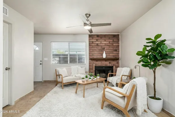 a living room with furniture potted plant and a large window