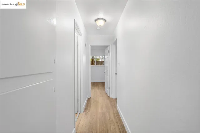 a view of a hallway with wooden floor
