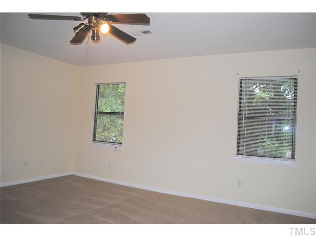 5745 3 Oaks Drive Raleigh, NC 27612 - Photo 8 of 12 an empty room with windows and ceiling fan