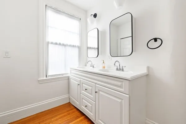 a bathroom with a double vanity sink and a window