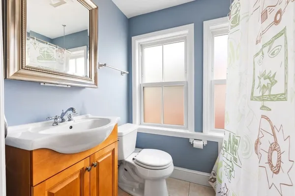 a bathroom with a sink a toilet and a window