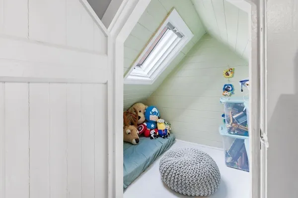 a living room with furniture and a baby crib