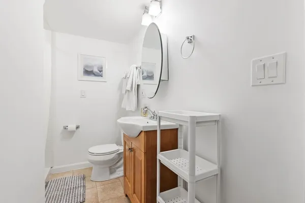 a bathroom with a toilet a sink and mirror