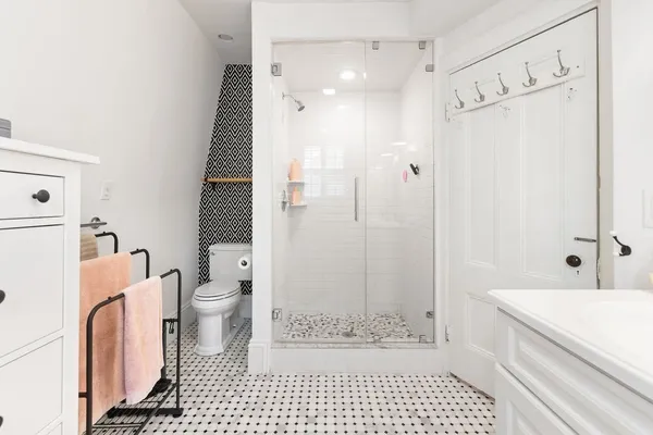 a bathroom with a granite countertop bathtub shower sink mirror and toilet