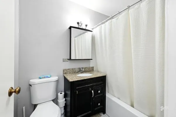 a bathroom with a sink a toilet and shower curtain