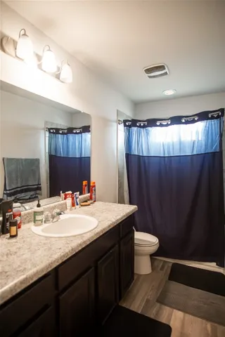 a bathroom with a sink a toilet a mirror and shower