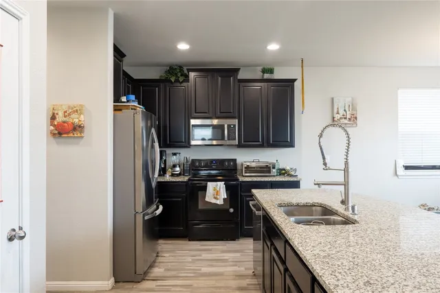 a kitchen with granite countertop stainless steel appliances and refrigerator