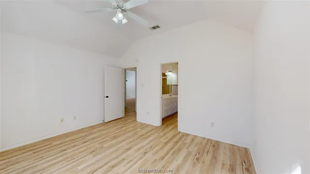 a view of a room with wooden floor and a ceiling fan