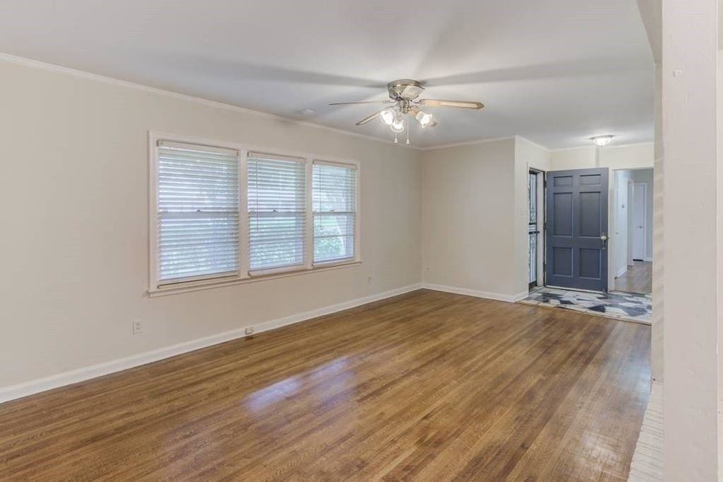 4811 Mockingbird Lane Memphis, TN 38117 - Photo 10 of 19 an empty room with wooden floor chandelier fan and windows