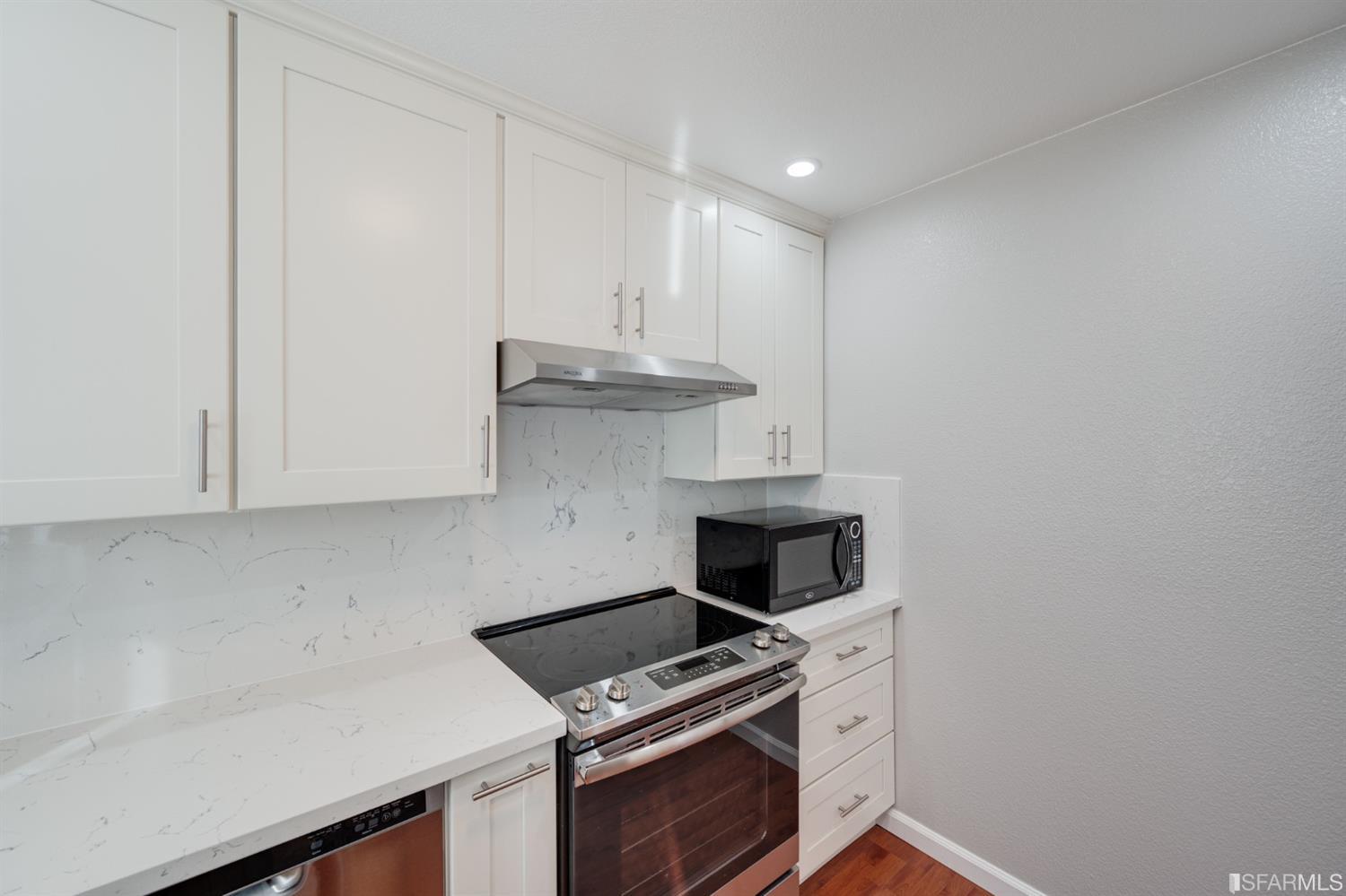 511 King Drive, Unit 5 Daly City, CA 94015 - Photo 23 of 51 a kitchen with granite countertop a stove and a white cabinets