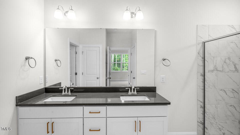 2222 Redpoll Drive Apex, NC 27539 - Photo 26 of 38 a bathroom with a granite countertop sink and a mirror