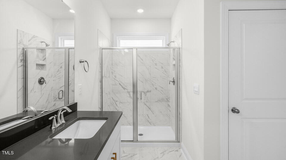 2222 Redpoll Drive Apex, NC 27539 - Photo 27 of 38 a bathroom with a granite countertop sink mirror and shower