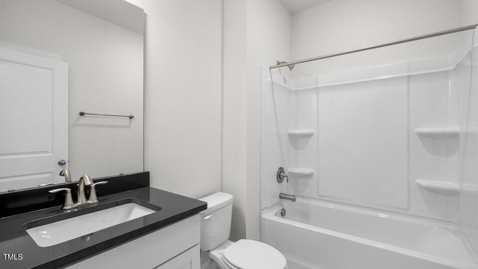 2222 Redpoll Drive Apex, NC 27539 - Photo 29 of 38 a bathroom with a granite countertop sink toilet and shower