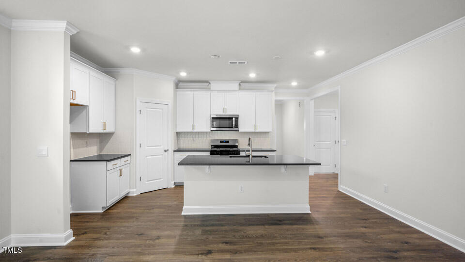2222 Redpoll Drive Apex, NC 27539 - Photo 6 of 38 a large kitchen with granite countertop a stove top oven a sink dishwasher and a refrigerator with wooden floor