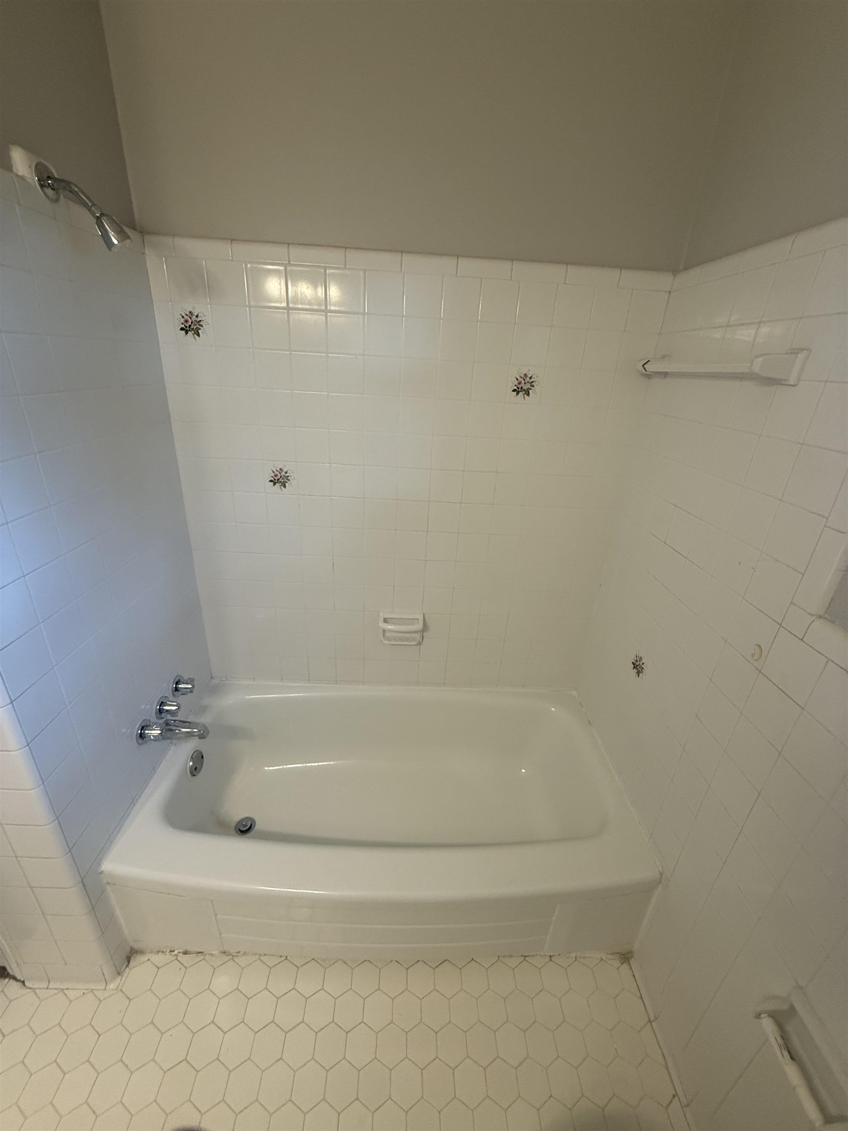1918 Cherry Road Memphis, TN 38117 - Photo 18 of 26 White bathtub and shower surround with decorative floral accent tiles