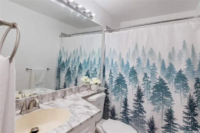 a bathroom with a granite countertop sink and a mirror with toilet