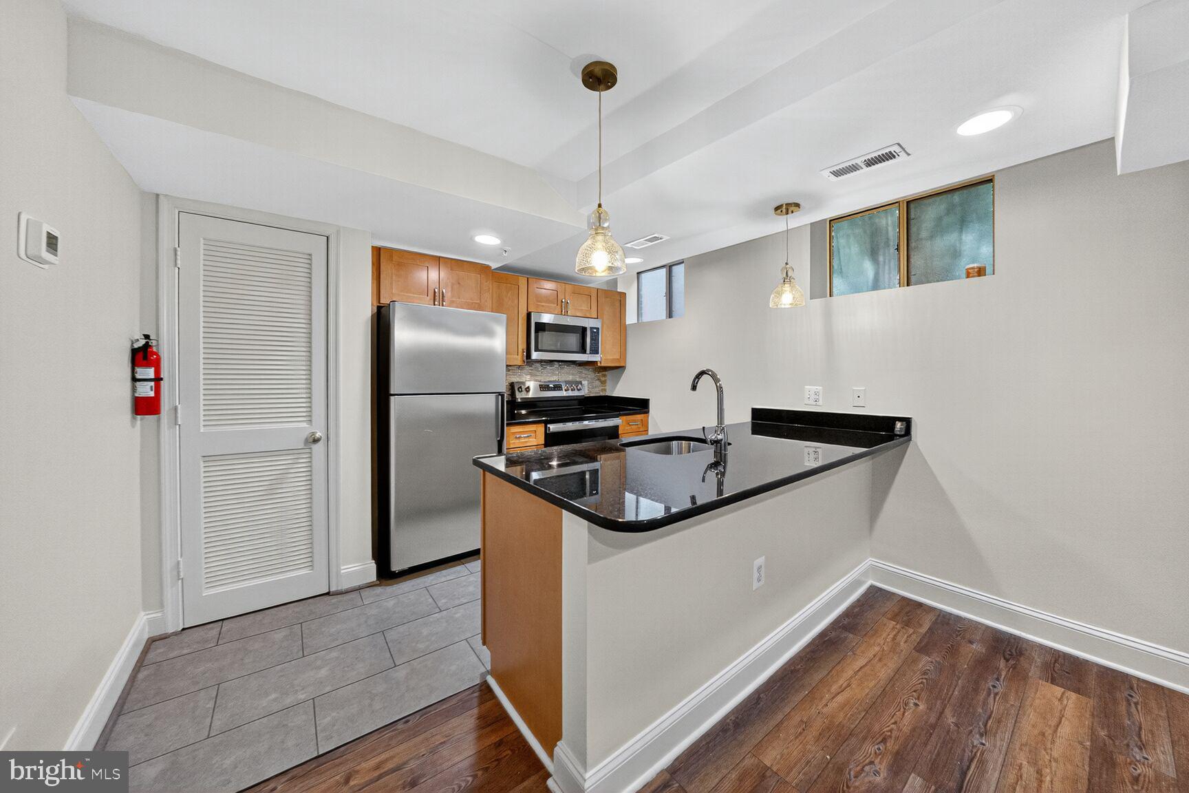 5407 9th Street Northwest, Unit 8 Washington, DC 20011 - Photo 6 of 16 a kitchen with stainless steel appliances granite countertop a sink and a refrigerator