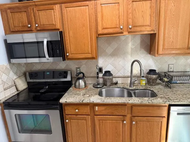 a kitchen with granite countertop a sink a stove and cabinets