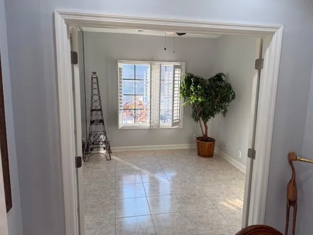 a view of an entryway with a flower pot and table in front of a window