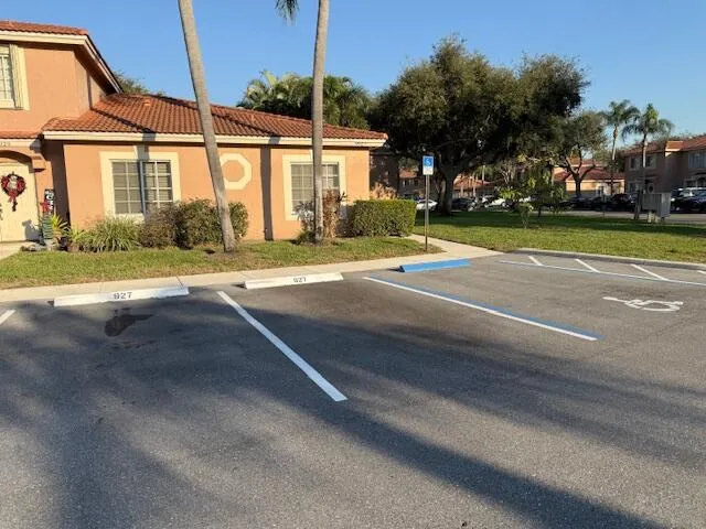 a view of a house with a big yard and palm trees