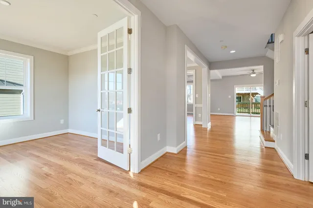 a view of a hallway with wooden floor and a living room