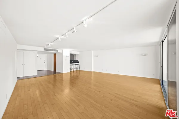 a view of empty room with wooden floor