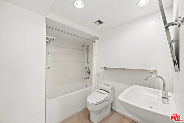a bathroom with a sink toilet and shower