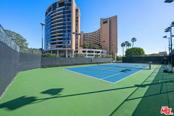 a view of a tennis ground with large windows