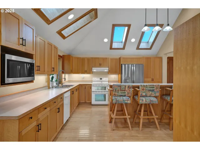 a kitchen with stainless steel appliances granite countertop a refrigerator and a stove top oven
