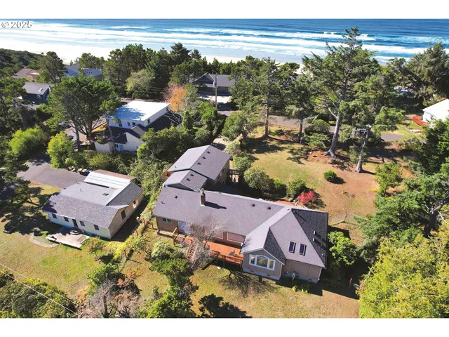 an aerial view of a house with a yard and lake view
