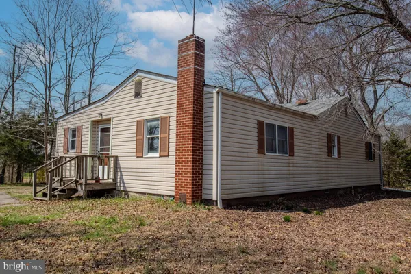 a view of a house with a yard and wooden fence