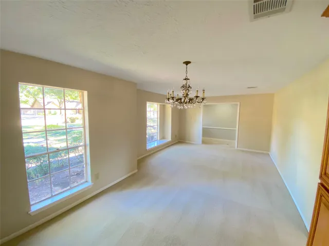 a view of an empty room with a fireplace and a window