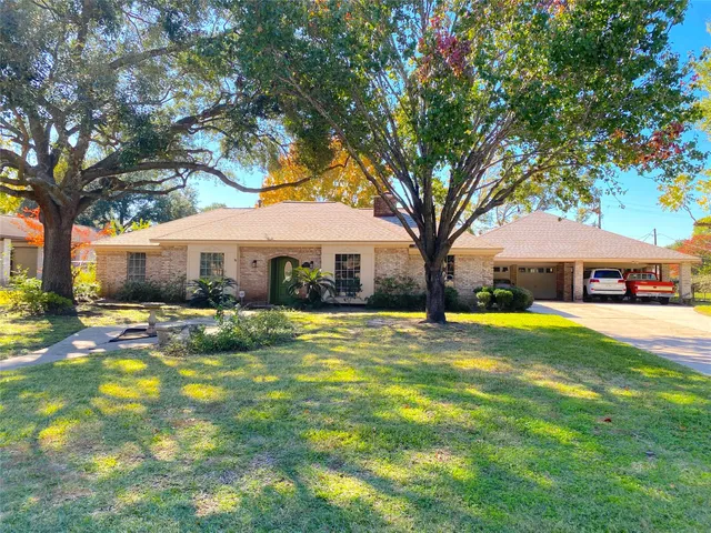 a front view of a house with swimming pool and trees