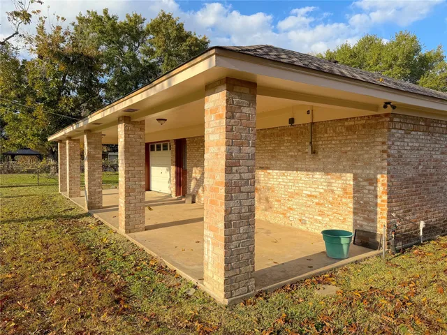a view of swimming pool with lawn chairs and large trees