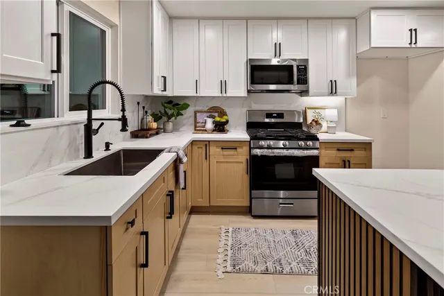 a kitchen with white cabinets and stainless steel appliances