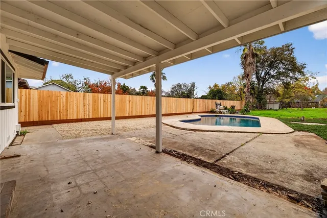 a swimming pool view with a seating space and a garden view