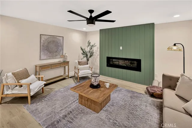 a living room with furniture a flat screen tv and a fireplace