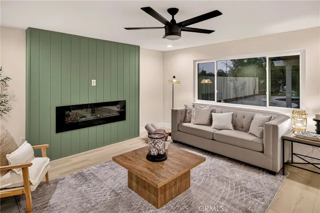 a living room with furniture kitchen view and a large window