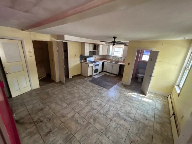 a living room with furniture and a refrigerator