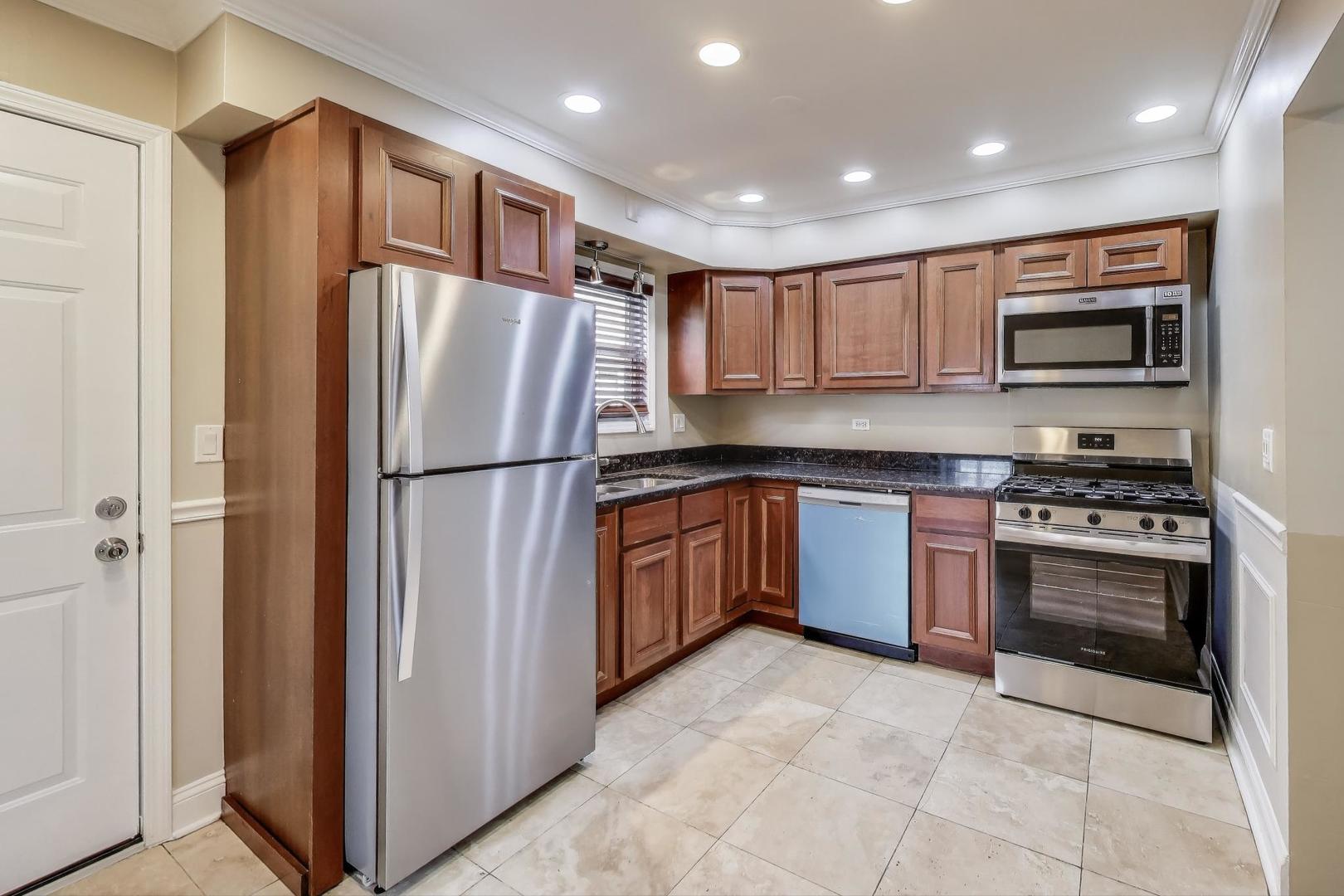 2019 Georgetown Lane, Unit 2019 Waukegan, IL 60085 - Photo 11 of 31 a kitchen with stainless steel appliances granite countertop a refrigerator and a stove top oven