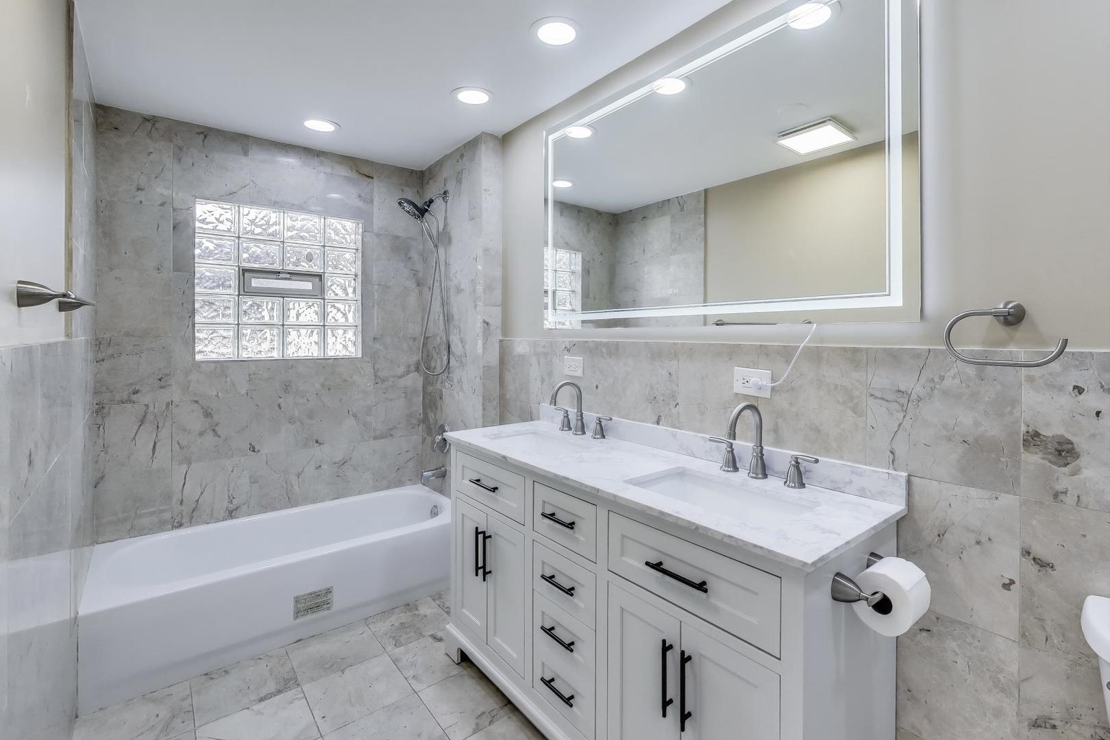 2019 Georgetown Lane, Unit 2019 Waukegan, IL 60085 - Photo 24 of 31 a bathroom with a tub sink and mirror