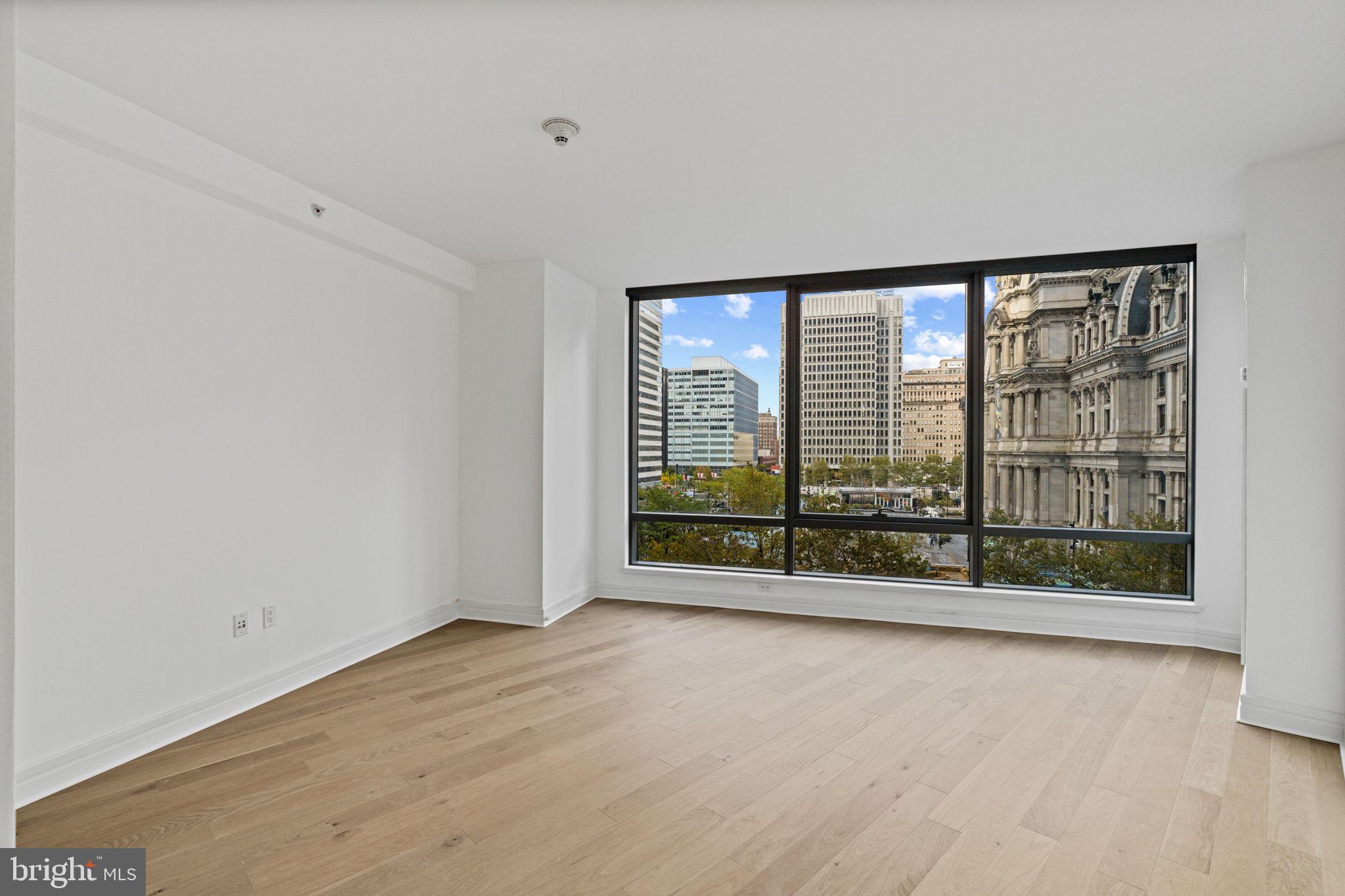 1414 South Penn Square, Unit 5B Philadelphia, PA 19102 - Photo 9 of 38 an empty room with wooden floor and windows