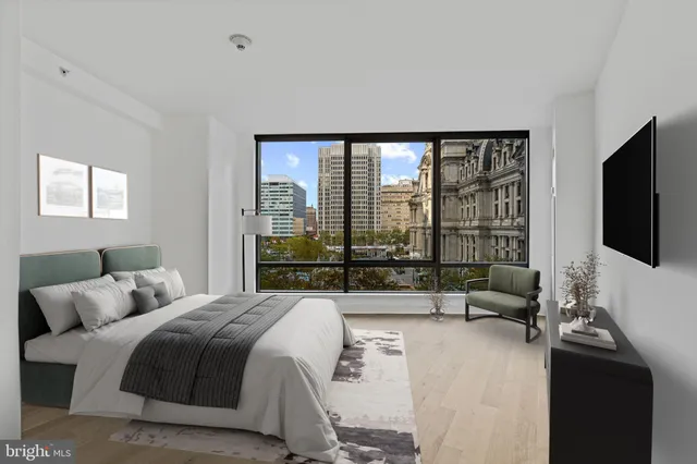 a large bedroom with a bed and large window