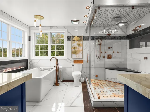 a bathroom with a sink toilet a mirror and shower