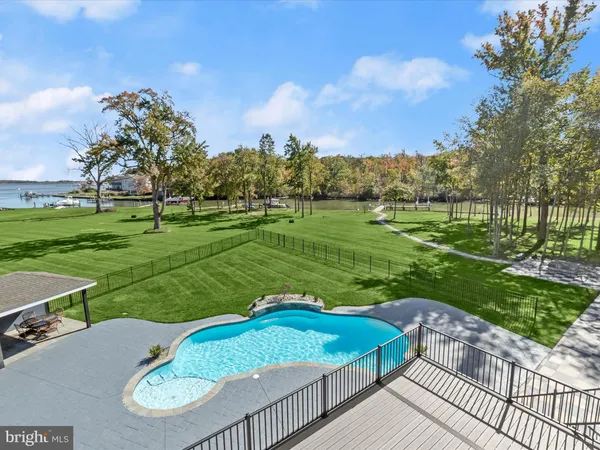 a view of a park with large trees and a wooden fence
