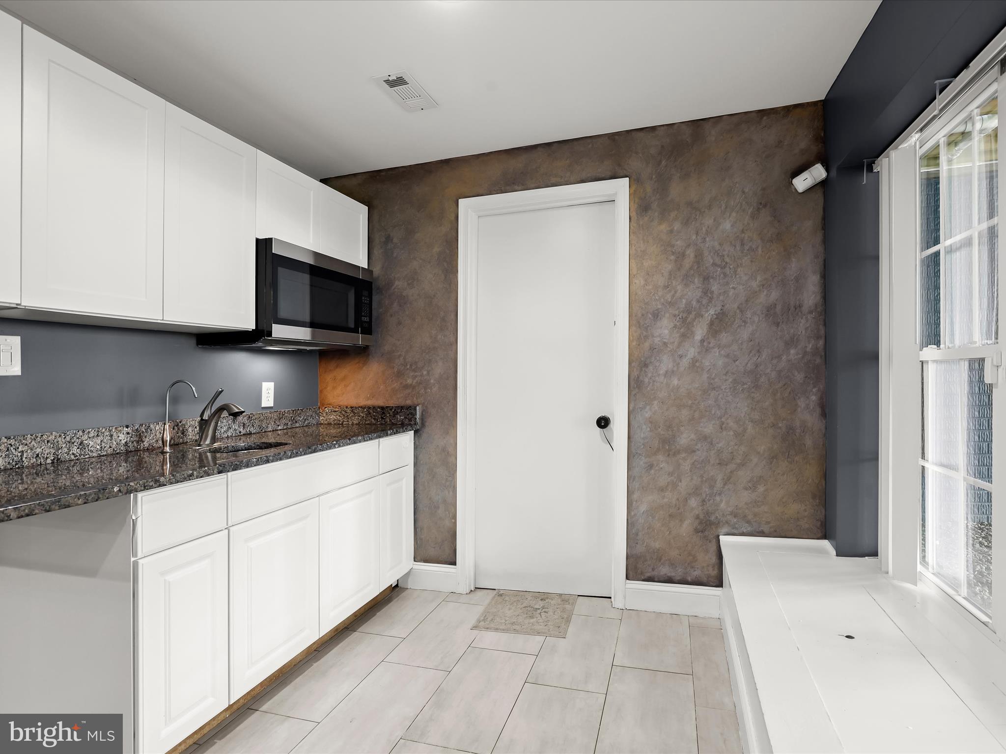 1315 South Seneca Road Middle River, MD 21220 - Photo 62 of 127 a kitchen with granite countertop a sink a stove top oven a refrigerator and white cabinets